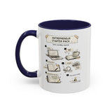 A white ceramic mug with a dark navy blue handle and interior, featuring a printed graphic titled 'Entrepreneur Starter Pack' with illustrated steps and objects like a laptop, notebook, coffee mug, and charger.