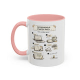 A white ceramic mug with a pink handle and pink interior, featuring a printed graphic titled 'Entrepreneur Starter Pack' with illustrated steps and small drawings of a laptop, notebook, coffee cup, and other startup-themed items.